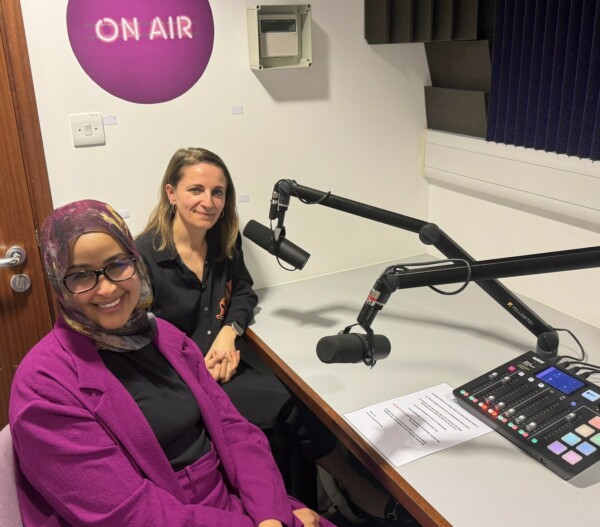 Dr Ola Abdelhadi and Professor Sandra Bucci in the podcast studio. They are sitting in front of 2 microphones and audio controls.